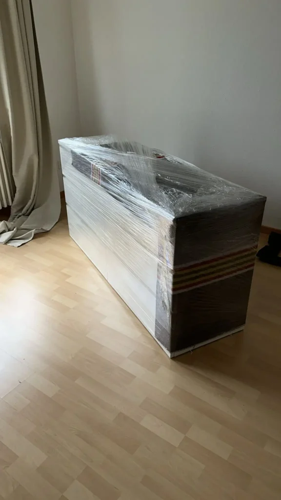 Sideboard komplett in Umzugsdecke und Stretchfolie verpackt, bereit für den Transport – sorgfältiger Möbelschutz beim Privatumzug mit UTZ.